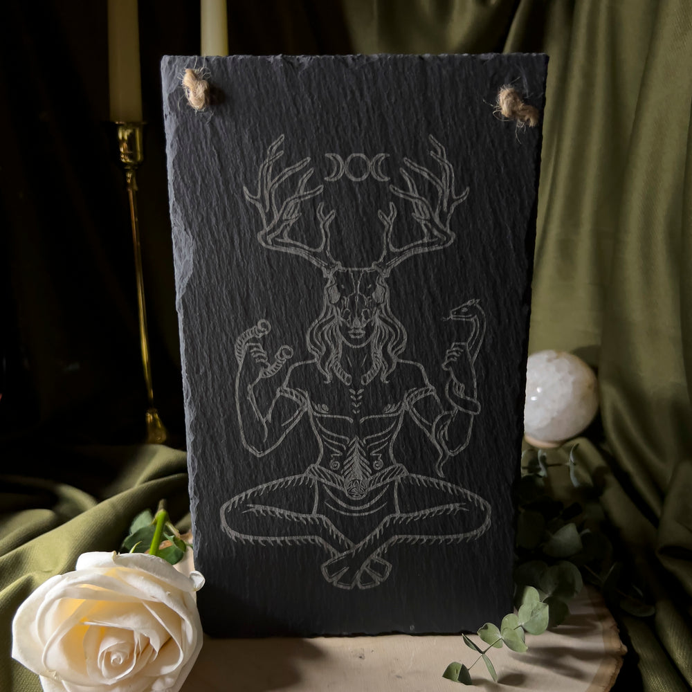 Cernunnos sitting down with a deer skull on his head carved into a slate art tile.