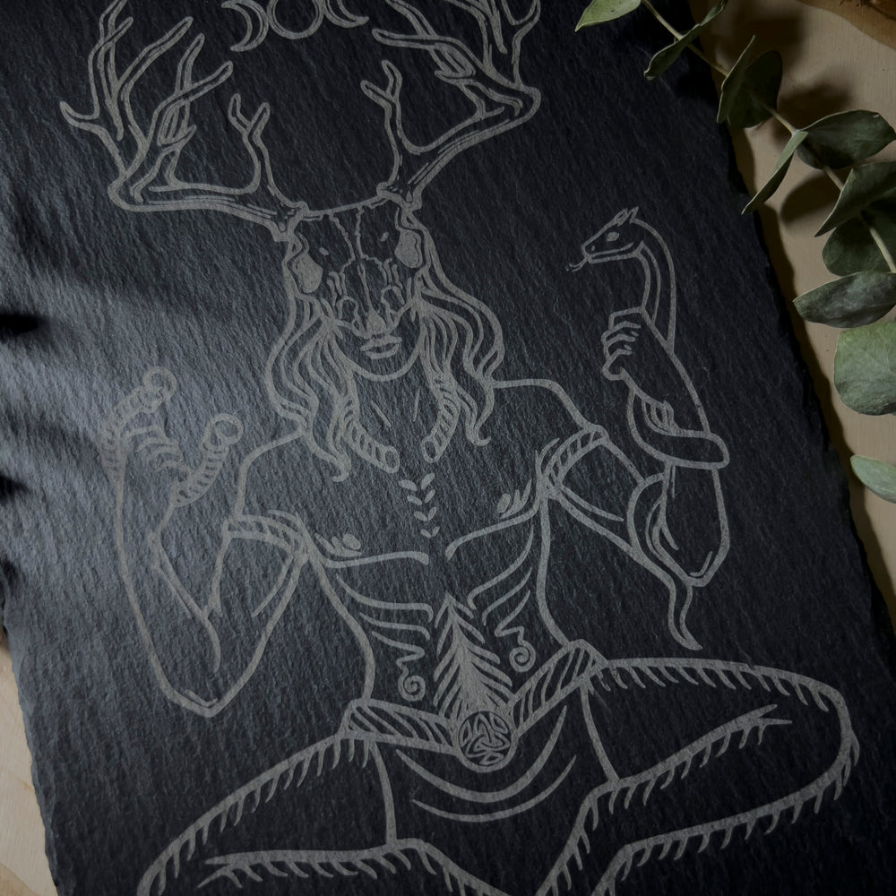 Cernunnos sitting down with a deer skull on his head carved into a slate art tile.