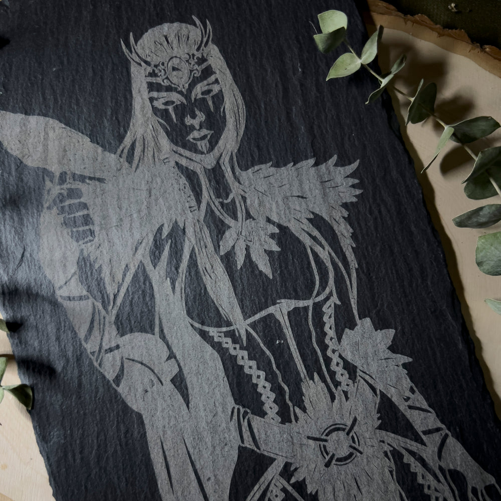 Slate art depicting the goddess The Morrigan holding her crow.