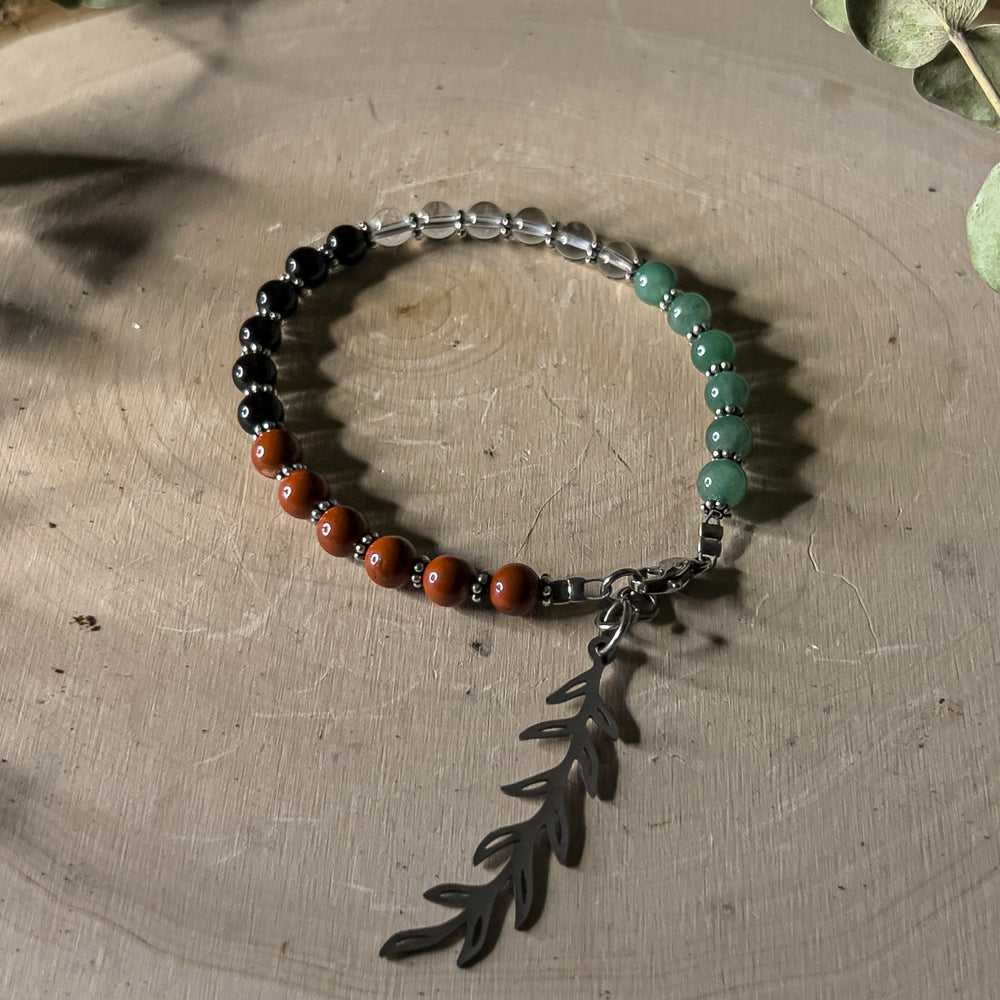 A bracelet with gemstone beads in the colors of the Palestinian flag with an olive branch charm. 